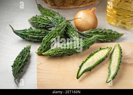 Frische Gruppe von rohen frischen Bittermelone Gemüse und ein Eine Nahaufnahme auf einem Schneidebrett halbiert Stockfoto