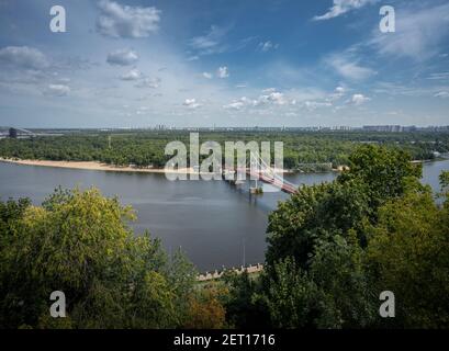 Luftaufnahme des Dnjepr-Flusses und der Parkovy-Fußgängerbrücke - Kiew, Ukraine Stockfoto