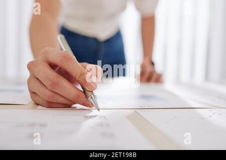 Geschäftsmann prüft Zahlen in Berichten Stockfoto