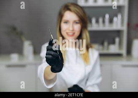 Junge attraktive Arzt mit Spritze. Kosmetologe in Innenräumen macht eine Injektion. Hände halten Spritze. Frau in der Arztstube. Stockfoto