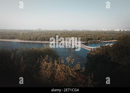 Luftaufnahme des Dnjepr-Flusses und der Parkovy-Fußgängerbrücke - Kiew, Ukraine Stockfoto