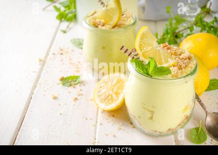Kein gebackener hausgemachter Zitronenkäsekuchen mit Minze im kleinen Jahrgang Gläser Stockfoto