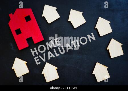 Heimbewertungskonzept. Kleine Holzhäuser auf der dunklen Oberfläche. Stockfoto