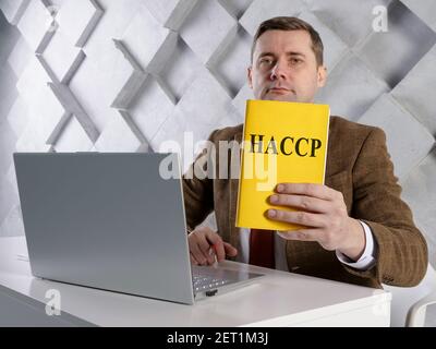 Der Manager zeigt die HACCP-Dokumente zur Gefahrenanalyse und zu kritischen Kontrollpunkten. Stockfoto