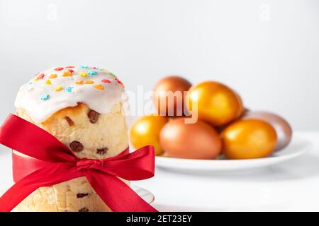 Osterkuchen mit süßem Glasur und goldenen Eiern auf weißem Teller. Alles gute im Frühling. Stockfoto