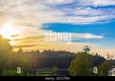 Schöner orange gelber Himmel. Sonnenuntergang über Wald und See in Norwegen. Stockfoto