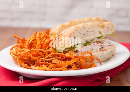 putenfocaccia-Sandwich mit handgemachten frittierten Süßkartoffeln Sprialchips Stockfoto