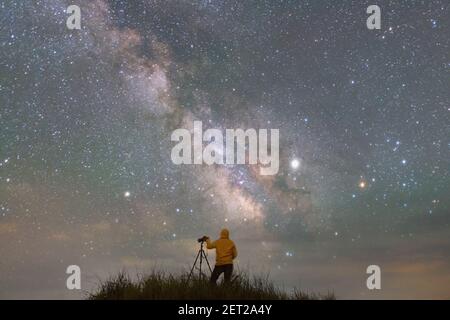 Rückansicht eines Mannes, der ein Foto vom Nachthimmel in Thailand macht Stockfoto