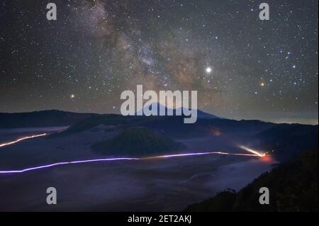 Luftaufnahme von Ampelwegen durch Berge unterhalb der Milchstraße, Thailand Stockfoto