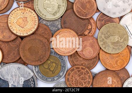 Schicht von Münzen aus verschiedenen Ländern. Objekt mit Kunstlicht von oben beleuchtet. Stockfoto