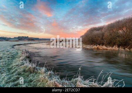 Ein frostiger Winteraufgang über dem Fluss Frome bei Holmebridge Zwischen Wolle und Wareham in der Dorset-Landschaft Stockfoto