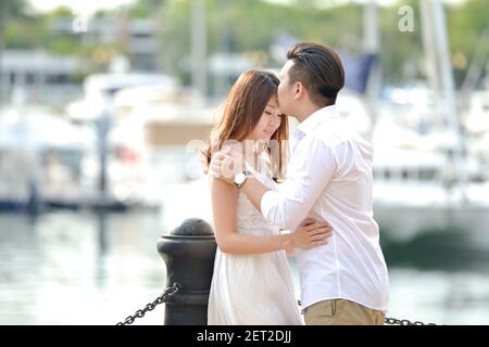 Porträt eines verliebten Paares, das an einer Marina in Singapur steht Stockfoto