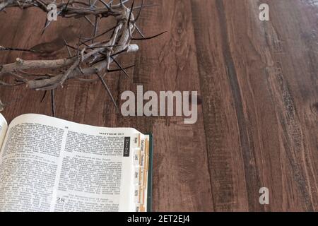 Öffnen sie bibel und Dornenkrone auf dunklem Holztisch Mit Kopierbereich Stockfoto