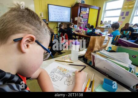 Ein Schüler der Klasse des Lehrers Elish Hanratty bei Scoil Naomh Lorcan in Omeath, Farben in einem St. Patrick's Day Poster, als Junior Kleinkinder bis 3rd Klassenschülern in die Schule zurückkehren. Mehr als 300.000 Schüler sind zum ersten Mal seit Dezember nach Aufhebung der Pandemiebeschränkungen in Klassenzimmer im ganzen Land zurückgekehrt. Stockfoto