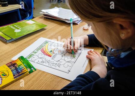 Ein Schüler der Klasse des Lehrers Elish Hanratty bei Scoil Naomh Lorcan in Omeath, Farben in einem St. Patrick's Day Poster, als Junior Kleinkinder bis 3rd Klassenschülern in die Schule zurückkehren. Mehr als 300.000 Schüler sind zum ersten Mal seit Dezember nach Aufhebung der Pandemiebeschränkungen in Klassenzimmer im ganzen Land zurückgekehrt. Stockfoto