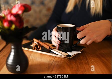 Frau, die an einem Tisch sitzt und eine Tasse Kaffee genießt Stockfoto