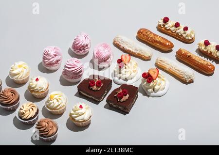 Flache Lay Zusammensetzung von süßem Gebäck auf grauem Hintergrund. Draufsicht. Leckere Kuchen dekoriert. Stockfoto