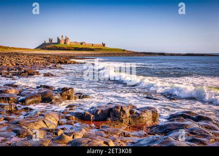 Dunstanburgh Castle an der Northumberland Küste an einem klaren Frühlingsmorgen. Stockfoto