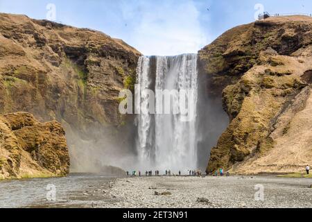 22. April 2018: Skogafoss, Südisland. - Besucher am Fuße des Skogafoss Wasserfall, Süd-Island. Stockfoto