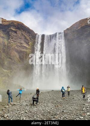 22. April 2018: Skogafoss, Südisland. - Besucher posieren für Fotos am Skogafoss Wasserfall, Süd-Island. Stockfoto