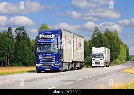 Zwei Scania-Gütertransportwagen, blaue DB Schenker im Vordergrund, transportieren im Sommer Güter auf dem Highway 10. Jokioinen, Finnland. 7. August 2020 Stockfoto