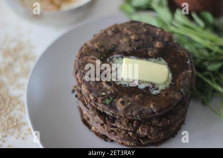 Fladenbrot mit Fingerhirse und Bockshornkleeblättern serviert mit Masala Quark. Es wird auch Nachni methi thepla genannt, ein gesundes und leckeres Fladenbrot aus Stockfoto