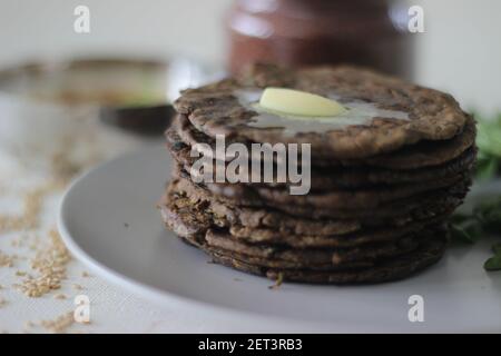 Fladenbrot mit Fingerhirse und Bockshornkleeblättern serviert mit Masala Quark. Es wird auch Nachni methi thepla genannt, ein gesundes und leckeres Fladenbrot aus Stockfoto