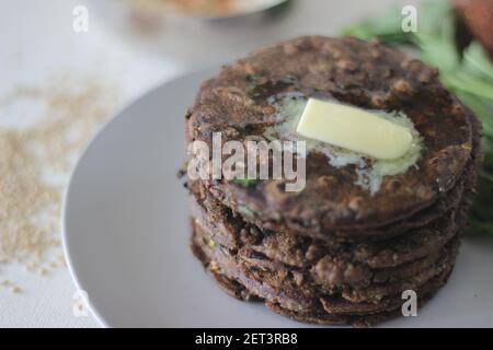 Fladenbrot mit Fingerhirse und Bockshornkleeblättern serviert mit Masala Quark. Es wird auch Nachni methi thepla genannt, ein gesundes und leckeres Fladenbrot aus Stockfoto