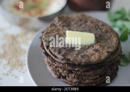 Fladenbrot mit Fingerhirse und Bockshornkleeblättern serviert mit Masala Quark. Es wird auch Nachni methi thepla genannt, ein gesundes und leckeres Fladenbrot aus Stockfoto