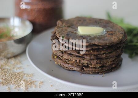 Fladenbrot mit Fingerhirse und Bockshornkleeblättern serviert mit Masala Quark. Es wird auch Nachni methi thepla genannt, ein gesundes und leckeres Fladenbrot aus Stockfoto