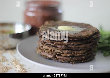 Fladenbrot mit Fingerhirse und Bockshornkleeblättern serviert mit Masala Quark. Es wird auch Nachni methi thepla genannt, ein gesundes und leckeres Fladenbrot aus Stockfoto