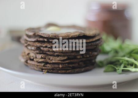 Fladenbrot mit Fingerhirse und Bockshornkleeblättern serviert mit Masala Quark. Es wird auch Nachni methi thepla genannt, ein gesundes und leckeres Fladenbrot aus Stockfoto