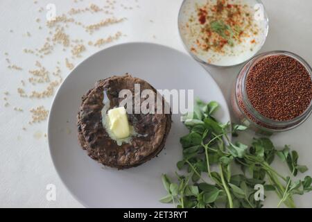 Fladenbrot mit Fingerhirse und Bockshornkleeblättern serviert mit Masala Quark. Es wird auch Nachni methi thepla genannt, ein gesundes und leckeres Fladenbrot aus Stockfoto