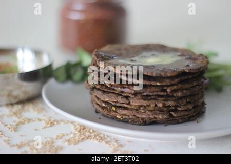 Fladenbrot mit Fingerhirse und Bockshornkleeblättern serviert mit Masala Quark. Es wird auch Nachni methi thepla genannt, ein gesundes und leckeres Fladenbrot aus Stockfoto