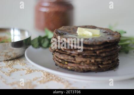 Fladenbrot mit Fingerhirse und Bockshornkleeblättern serviert mit Masala Quark. Es wird auch Nachni methi thepla genannt, ein gesundes und leckeres Fladenbrot aus Stockfoto