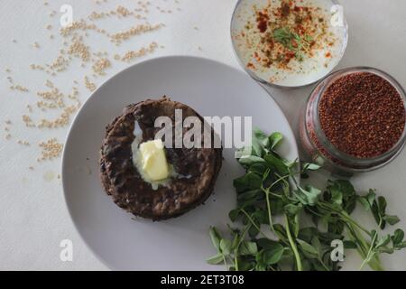 Fladenbrot mit Fingerhirse und Bockshornkleeblättern serviert mit Masala Quark. Es wird auch Nachni methi thepla genannt, ein gesundes und leckeres Fladenbrot aus Stockfoto