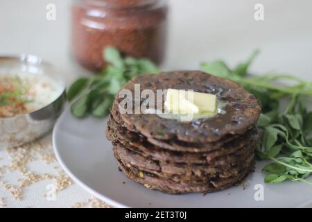 Fladenbrot mit Fingerhirse und Bockshornkleeblättern serviert mit Masala Quark. Es wird auch Nachni methi thepla genannt, ein gesundes und leckeres Fladenbrot aus Stockfoto