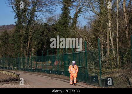 Wendover, Großbritannien. 28th. Februar 2021. Ein HS2-facher Sicherheitsmitarbeiter bewacht ein Waldgebiet neben der kleinen Dean Lane, die derzeit für die Hochgeschwindigkeitsstrecke HS2 freigegeben wird. Anti-HS2-Aktivisten besetzen weiterhin das Wendover Active Resistance Camp auf der gegenüberliegenden Seite der Bahnlinie vom Wald aus. Kredit: Mark Kerrison/Alamy Live Nachrichten Stockfoto