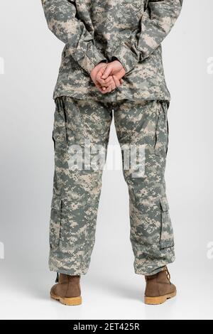 Rückansicht der Frau in Militäruniform auf grauem Hintergrund Stockfoto