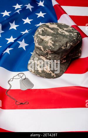 Militärische Mütze und Hundeanhänger auf amerikanischer Flagge Stockfoto