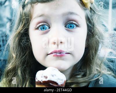 Porträt eines überraschten Mädchen mit stechenden blauen Augen essen Eis Stockfoto