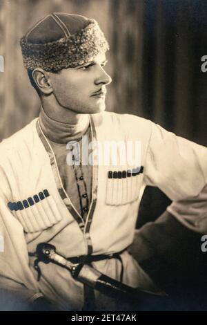 Russland - UM 1920s: Schöner junger Mann, der das traditionelle kaukasische Mtshketoba oder Chokha Männerkleid trägt, mit Bandoliers gefüllt mit Kugeln und Kha Stockfoto