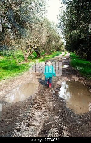 Mädchen, die auf einem schlammigen Wanderweg in der Landschaft, Italien Stockfoto