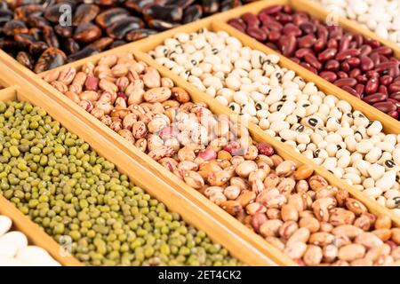 Verschiedene Bohnen in der Holzkiste. Scaelet Läufer, Mung, borlotti, schwarze Augen, adzuki, Rote Niere. Stockfoto