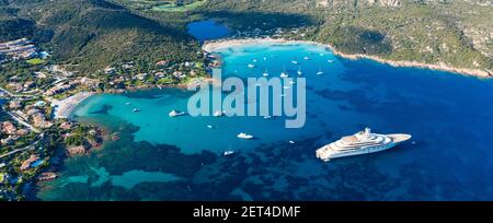 Blick von oben, atemberaubende Luftaufnahme des Grande Pevero Strandes mit Booten und Luxusyachten, die auf einem türkisfarbenen, klaren Wasser segeln. Sardinien, Italien. Stockfoto