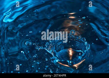 Wassertropfen und Wellen auf einem schönen farbigen Hintergrund. Erstaunliche natürliche Wasser Hintergrund Textur. Stockfoto