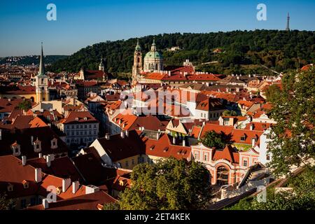 Malerisches rotes Dach von historischen Gebäuden in Prag Kleinseite, St. Nikolas Kirche und Berg Petrin mit Aussichtsturm. Blick vom Schlossgarten und Stockfoto