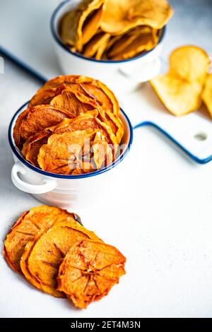 Schalen von getrockneten Apfel und Kaki Fruchtchips auf einem Tabelle Stockfoto