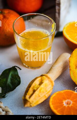 Ein Glas frisch gepresster Orangensaft und frische Orangen Stockfoto