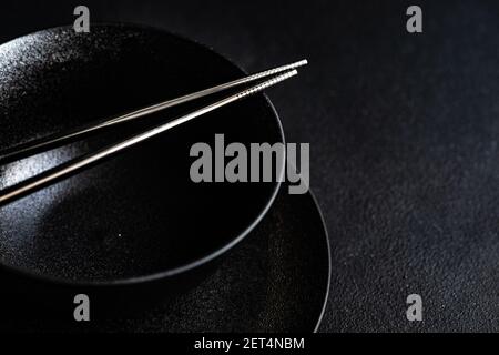 Blick von oben auf eine asiatische Tischeinstellung mit schwarzem Geschirr Stockfoto